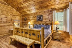 a log cabin bedroom with a bed and a bench at Suite Sensations in Pigeon Forge