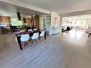 sala de estar con mesa de comedor y sillas blancas en Spacious home in idyllic neighbourhood, 15min to City en Sollentuna