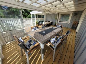 a wooden deck with a table and chairs on it at Spacious home in idyllic neighbourhood, 15min to City in Sollentuna