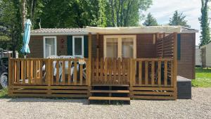 Cabaña de madera con puerta y porche en Nathalie et Yannick E53 E54 G15 G16 Mobil home climatisé Proche europapark, en Boofzheim