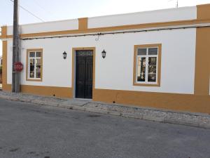 a white building with a black door and a stop sign at Cantinho de Terena in Terena
