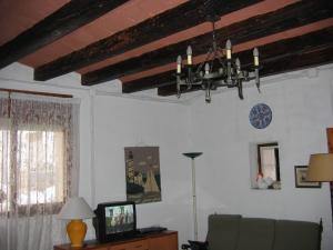 a living room with a chandelier and a television at Casa De Maestro, costa Dorada in Alcanar