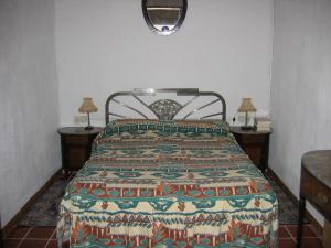 a bed in a room with two tables and a bedspread at Casa De Maestro, costa Dorada in Alcanar