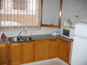 a kitchen with a sink and a microwave at Casa De Maestro, costa Dorada in Alcanar