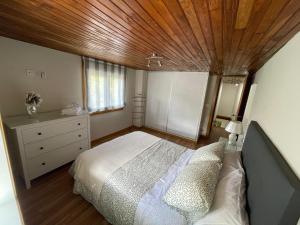 1 dormitorio con cama y techo de madera en Casa Rabelas en Chantada