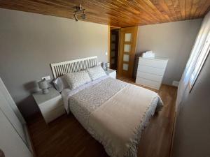um quarto com uma cama e um tecto de madeira em Casa Rabelas em Chantada