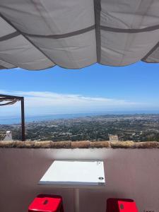 a table and two red chairs in a room with a view at ALMAFUERTE in Mijas