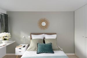 biała sypialnia z łóżkiem i lustrem na ścianie w obiekcie HOTEL LES PORTES DE PARIS w mieście Ivry-sur-Seine