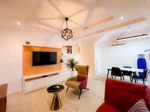 a living room with a couch and a tv and a table at Box Residence Hotel in Lagos