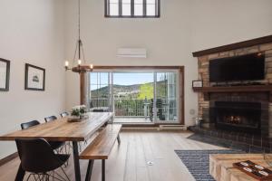 a living room with a table and a fireplace at Tremblant Prestige - Manoir 120-6 in Mont-Tremblant