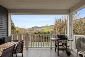 a screened in porch with a grill and a table at Tremblant Prestige - Manoir 120-6 in Mont-Tremblant