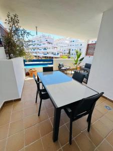 einen Tisch und Stühle auf einem Balkon mit Pool in der Unterkunft Duquesa suites golf and garden in Castillo de Sabinillas