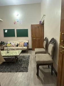 un soggiorno con 2 sedie e un divano di Stay At The Home a Varanasi