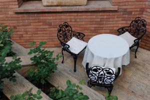 una mesa y dos sillas con un mantel blanco. en La Maison de Caroline en Alba Iulia