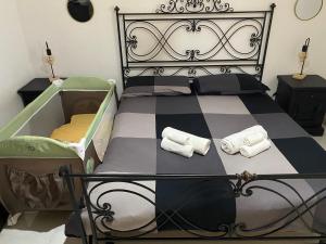 a bedroom with a black and white bed with towels on it at Belvedere House Holiday Siracusa Ortigia in Belvedere