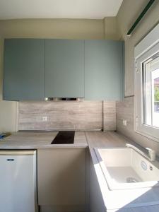 a white kitchen with a sink and a window at Venice Studios & Apartments in Stavros +22 photos