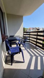 dwa niebieskie krzesła i stoły na balkonie w obiekcie Międzyzdroje Apartament Muszelka Centrum Blisko Morza w mieście Międzyzdroje