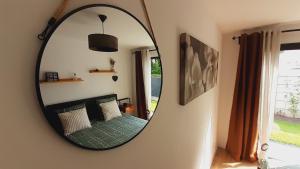 einen Spiegel in einem Zimmer mit einem Bett und einem Fenster in der Unterkunft L'atelier du Guette-Loup in Thouaré-sur-Loire