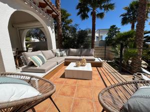 een patio met een bank, 2 stoelen en een tafel bij Casa El Mirador in Calpe