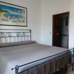 a bed in a room with a picture on the wall at Holiday rooms with private bathroom in Acilia