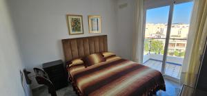una camera da letto con un letto e una grande finestra di Corazón Urbano a Martil