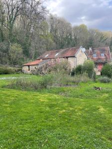 stary dom na polu zielonej trawy w obiekcie Ô Bonheurs Simples d'Ecorsaint Ici Doucement w mieście Hauteroche