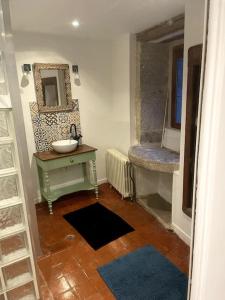ein Bad mit einem Waschbecken und einem Wandspiegel in der Unterkunft Ô Bonheurs Simples d'Ecorsaint Ici Doucement in Hauteroche