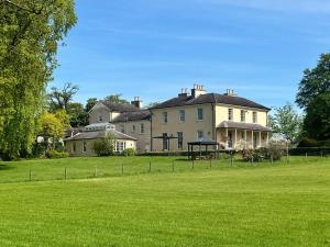 a large house with a grass field in front of it at Captain‘s Cottage in Llandeilo