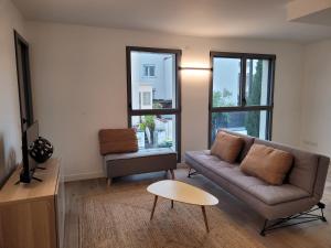 uma sala de estar com um sofá e uma mesa em Malakoff T2 Rue em Malakoff