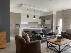 a living room with a couch and a table at Pinnacle Point Fynbos53 in Mossel Bay