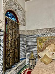 Riad Damia Suite &Spa في فاس: غرفة نوم بسرير ونافذة وطاولة