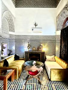 sala de estar con sofá y mesa en Riad Damia Suite &Spa, en Fez