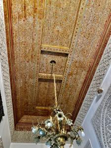 una lámpara de araña colgando del techo de una habitación en Riad Damia Suite &Spa, en Fez
