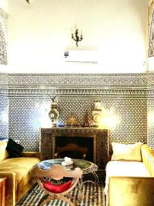 a living room with a table and a fireplace at Riad Damia Suite &Spa in Fez