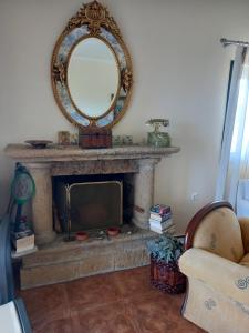 a room with a fireplace with a mirror and a tv at THEO house in Kyllini Zakynthos in Kyllini
