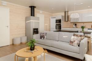 a living room with a couch and a kitchen at Näköalahuoneisto Iso-Syöte Ketunpolku in Syöte