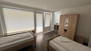 two beds in a room with windows and a mirror at Apartment in Hannover! contactless check-in in Hannover