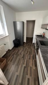 a kitchen with a refrigerator and a wooden floor at Apartment in Hannover! contactless check-in in Hannover