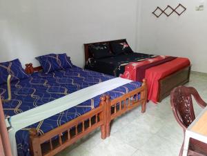 a bedroom with two beds and a couch at Nallur Mylooran Arangam in Jaffna