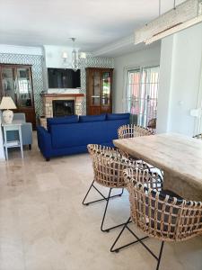 a living room with a blue couch and chairs at Villa Matisse Luxury Beach in Torremolinos