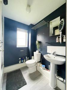 a blue bathroom with a toilet and a sink at Colliers Wood 1 Bed South London Short Stay in Mitcham