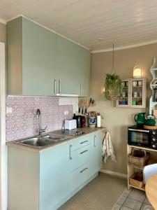 a kitchen with white cabinets and a sink at Sveggvika Atlantic Home in Averoy