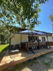 a house with a deck with a tent at Le Couart in Castets