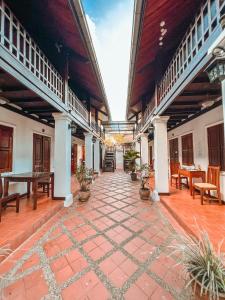 an outdoor patio with tables and chairs and a table at khong kham Hotel in Luang Prabang