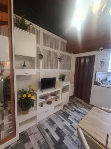 a living room with a tv and a table at La Casita in Gijón