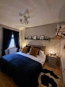 a bedroom with a large bed with a blue blanket at Bow Cottage in Abercraf