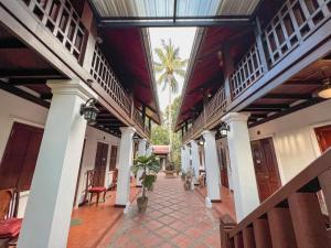 a courtyard of a house with a palm tree in the background at khong kham Hotel in Luang Prabang