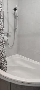 a bathroom with a shower with a white tub at Bow Cottage in Abercraf