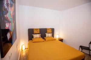 a bedroom with a yellow bed with two pillows at Casa de los hermanos in Almuñécar