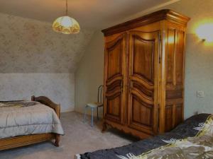 una camera da letto con un grande armadio in legno accanto a un letto di L'oscar a Saint-James